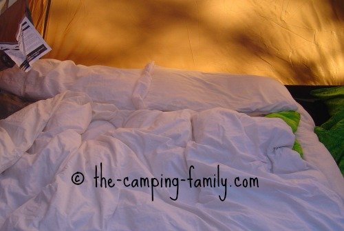 air bed with sheets and duvet, in tent