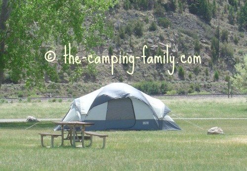 tent in sunny campground with trees